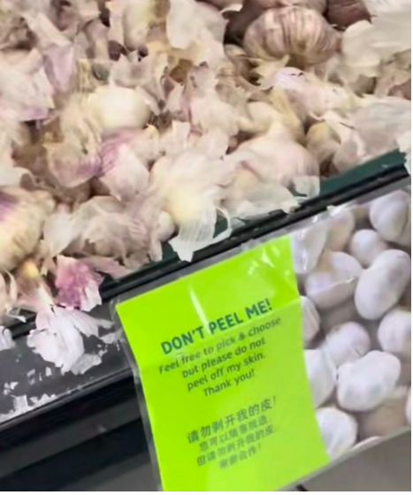 Wanita kupas kulit bawang putih saat belanja