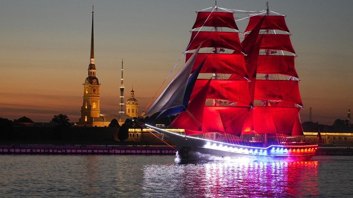 A brig with scarlet sails floats on the Neva River through the Troitsky drawbridge during a rehearsal for the Scarlet Sails festivities marking school graduation in St. Petersburg, Russia, early Tuesday, June 13, 2023. (AP Photo/Dmitri Lovetsky)