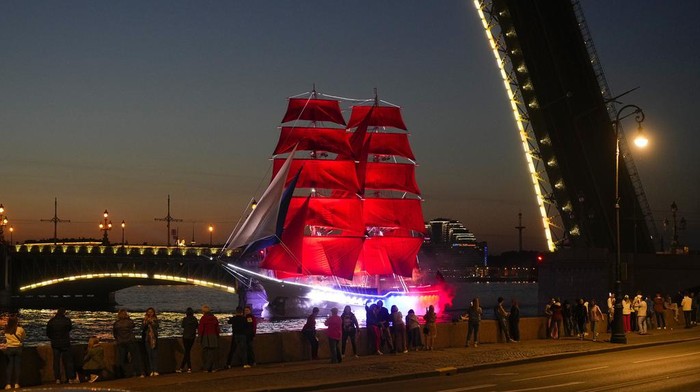 A brig with scarlet sails floats on the Neva River through the Troitsky drawbridge during a rehearsal for the Scarlet Sails festivities marking school graduation in St. Petersburg, Russia, early Tuesday, June 13, 2023. (AP Photo/Dmitri Lovetsky)