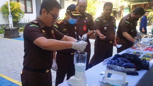 Kejari Karangasem saat melakukan pemusnahan barang bukti kejahatan dengan cara diblender, digeprek hingga dibakar, Rabu (14/6/2023). (I Wayan Selamat Juniasa)