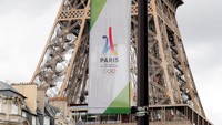 Sebuah spanduk logo Olimpiade 2024 Paris mulai dipasangkan di Menara Eiffel, Paris, Rabu (14/6/2024). REUTERS/Gonzalo Fuentes