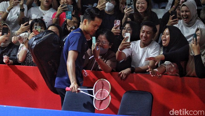 Senyum Anthony Ginting Menyapa Penonton Anthony Ginting menghadapi Hans-Kristian Vittinghus di penyisihan Indonesia Open 2023. Sebelum bertanding, Ginting sempat menyapa penonton dengan senyuman.