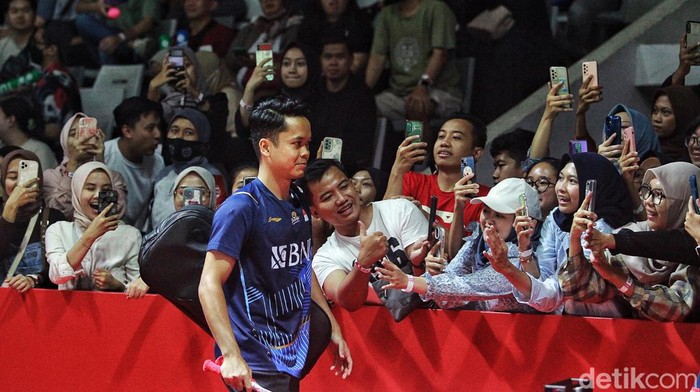 Anthony Ginting menghadapi Hans-Kristian Vittinghus di penyisihan Indonesia Open 2023. Sebelum bertanding, Ginting sempat menyapa penonton dengan senyuman.