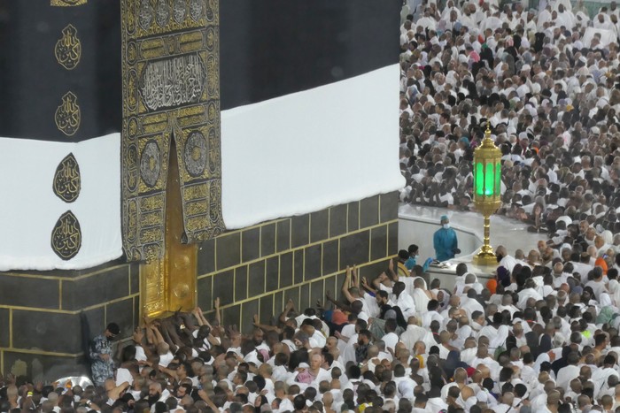 Jamaah calon haji berusaha memegang pintu Kabah di Masjidil Haram, Mekah, Arab Saudi, Selasa (13/6/2023). Kemenag mengimbau jamaah calon haji Indonesia tidak melaksanakan umrah wajib pada siang hari karena tingginya suhu udara di Mekah, Arab Saudi yang mencapai sekitar 45 derajat celcius.