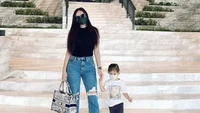 Aura Kasih mengenakan kaos hitam dan celana denim saat mengajak anaknya ke acara yang santai. Foto: Instagram Aura Kasih