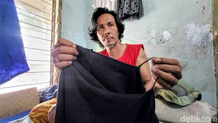 Jopie Arkeen Korban Pengeroyokan Sekelompok Orang memperlihatkan pakaian yang sobek