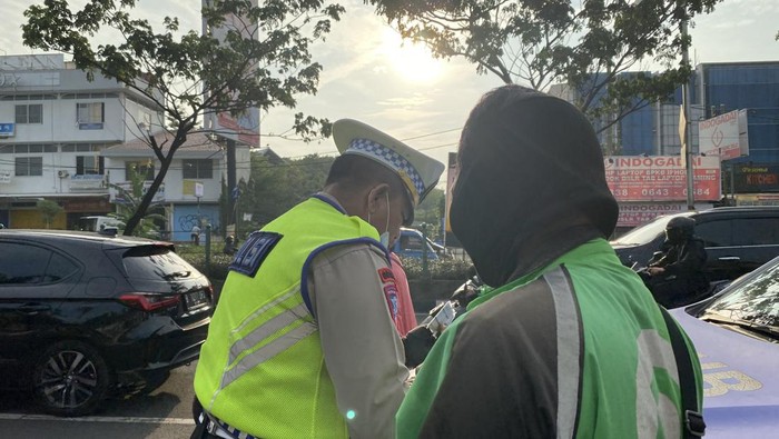 Polisi tilang ojek online yang parkir di bahu Jalan Margonda Depok.