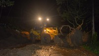 Petugas menggunakan alat berat saat membersihkan material longsor di Batipuh Ateh, Tanah Datar, Sumatera Barat, Rabu (14/6/2023) malam. 