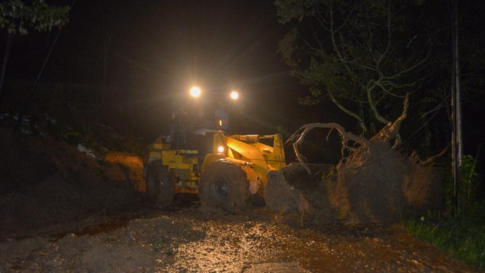 Petugas menggunakan alat berat saat membersihkan material longsor di Batipuh Ateh, Tanah Datar, Sumatera Barat, Rabu (14/6/2023) malam. Jalan utama perlintasan Padang - Batusangkar itu mengalami longsor akibat intensitas hujan tinggi dan menutup jalan sehingga akses terputus hingga empat jam lebih. ANTARA FOTO/Iggoy el Fitra/nym.