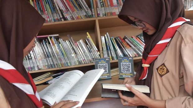 Seorang pelajar memindai kode QR menggunakan aplikasi Candil (Maca Dina Digital Library) untuk membaca buku secara digital di mobil perpustakaan keliling di SMK Telekomunikasi Telesandi, Tambun, Bekasi, Jawa Barat, Kamis (15/6/2023). Mobil perpustakaan keliling Dinas Kearsipan dan Perpustakaan (Dispusida) itu bertujuan untuk mendukung upaya pemerintah dalam meningkatkan minat baca serta meningkatkan budaya literasi siswa sekolah dan masyarakat umum. ANTARA FOTO/ Fakhri Hermansyah/nym.