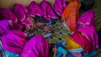 Sejumlah pengantin gadis Muslim mengenakan kain berwarna ungu dan oranye untuk menutupi kepalanya agar wajah pengantin tidak terlihat oleh calon pengantin pria.