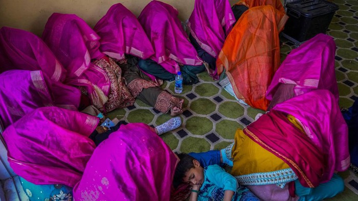 Sejumlah pengantin dengan ekonomi rendah mengikuti pernikahan massal di Kashmir, India. Uniknya, pengantin wanita ditutup dengan kain berwarna ungu dan oranye.