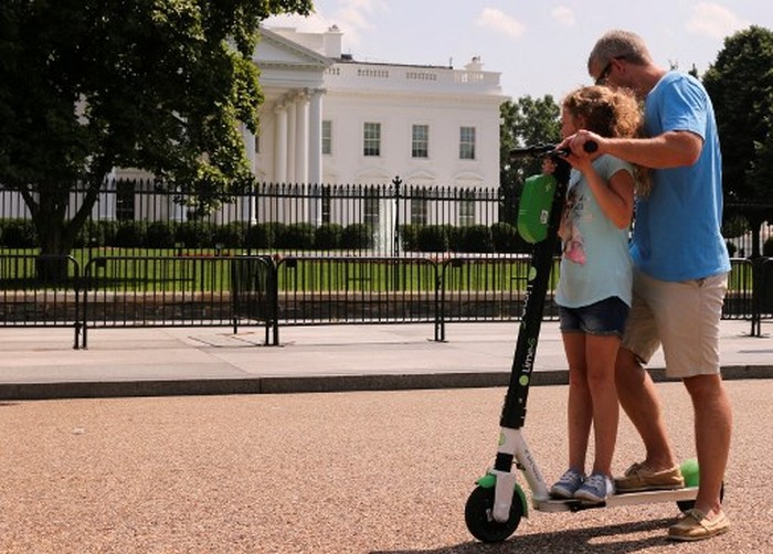 Man rides electric scooter in front of the White House on May 29, 2019 in Washington, DC. (Photo by Anna-Rose GASSOT / AFP)