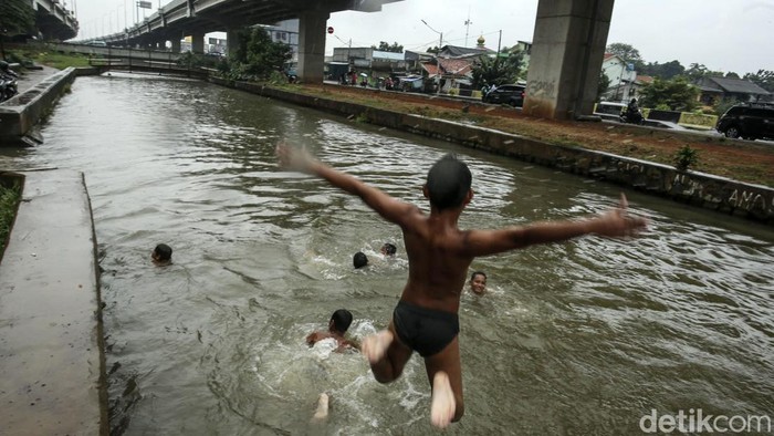 Aksi Bocil Taklukkan Arus Kalimalang Sejumlah anak-anak berenang di Kalimalang, Jakarta Timur, Jumat (16/6/2023). Meski dalam keadaan hujan, anak-anak tetap asyik berenang.