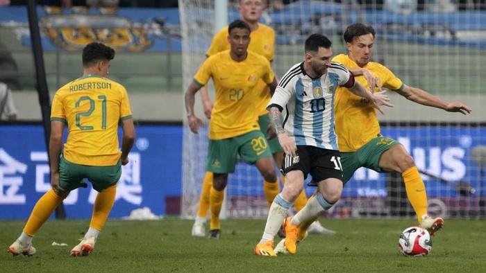 Argentinas Lionel Messi drives the ball past Australias Dennis Genreau during the second half of their friendly soccer match at Workers Stadium in Beijing, Thursday, June 15, 2023. (AP Photo/Mark Schiefelbein)