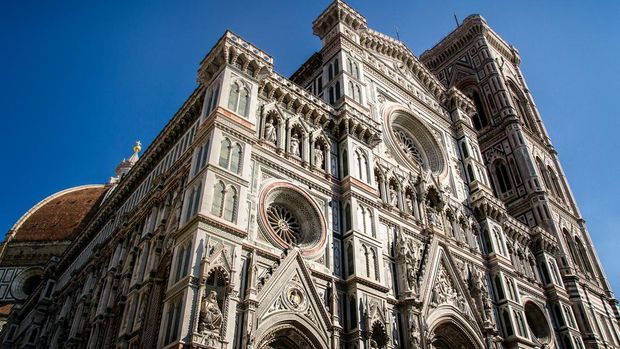 Florence cathedral viewed from the front-side with Giotto's bell tower on the right and Brunelleschi's dome on the left. Peculiar decorations are clearly visible.