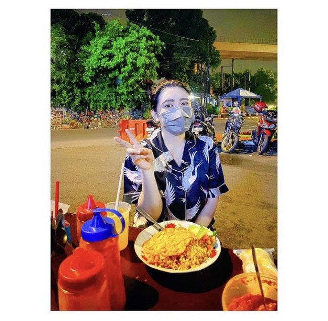 Via Vallen tampil sederhana saat makan nasi goreng di pinggir jalan. Pelantun lagu sayang itu mengenakan setelan piyama bercorak burung. Foto: Instagram