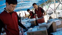 Pekerja pengiriman menyortir paket di ban berjalan, di stasiun logistik di Beijing, China, Jumat (16/6/2023). Beberapa perusahaan belanja online di China akan bersiap menyambut datangnya festival belanja tengah tahun atau festival belanja 618.