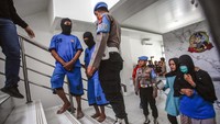 Polisi menggiring tersangka kasus tindak pidana perdagangan orang saat rilis di Mapolres Bogor, Cibinong, Kabupaten Bogor Jawa Barat, Rabu (14/6/2023). Sat Reskrim Polres Bogor membongkar sindikat pengiriman Tenaga Kerja Indonesia (TKI) ilegal ke Malaysia dan menangkap empat tersangka berinisial ED (63), AK (37), RA (32), dan LS (49) yang diduga terlibat dalam perekrutan serta pengiriman 61 pekerja imigran. ANTARA FOTO/Yulius Satria Wijaya  