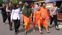 Polisi menggiring tiga tersangka saat gelar perkara tindak pidana perdagangan orang (TPPO) di Mapolresta Magelang, Jawa Tengah, Senin (12/6/2023). Jajaran Polresta Magelang mengungkap kasus tindak pidana pengiriman tenaga migran ilegal ke Malaysia serta mengamankan tiga tersangka berinisial SP (50), SF (51) dan WS (66) beserta barang bukti sejumlah paspor. ANTARA /Anis Efizudin