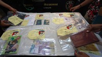 Petugas menata barang bukti kasus tindak pidana perdagangan orang (TPPO) saat rilis kasus di gedung Ditreskrimum Polda Metro Jaya, Jakarta, Jumat (9/6/2023). Ditreskrimum Polda Metro Jaya berhasil melakukan pengungkapan dan penangkapan dua tersangka TPPO di Jakarta Pusat dan Jakarta Timur dengan modus untuk menjadi pekerja Migran Indonesia keluar negeri secara non prosedural atau tidak memenuhi persyaratan Pekerja Migran Indonesia. ANTARA FOTO/Reno Esnir