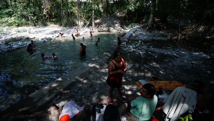 People cool off in the La Silla River as temperatures rise during an unusual heat wave, in Monterrey, Mexico June 15, 2023. REUTERS/Daniel Becerril