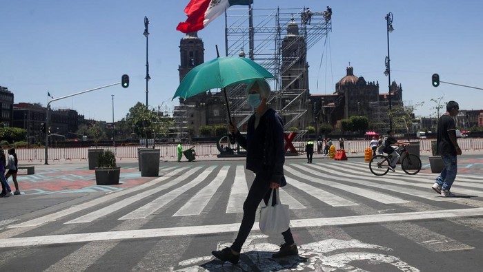 A woman holds an umbrella during a period of high temperatures in Mexico City, Mexico June 13, 2023. REUTERS/Henry Romero