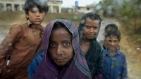 Anak-anak terlihat melalui jendela mobil saat hujan di luar kamp yang didirikan di sebuah gedung sekolah untuk pengungsi internal dari daerah pantai karena Topan Biparjoy mendekat, di Badin, distrik selatan Pakistan di provinsi Sindh, Kamis (15/6/2023).