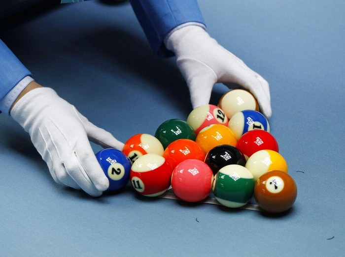 A game official racks the balls during a womens 8 ball pool singles match between South Koreas Cha You-ram and Thailands Chonticha Chitchonmart at the 16th Asian Games in Guangzhou, China, Wednesday, Nov. 17, 2010. (AP Photo/Dita Alangkara)
