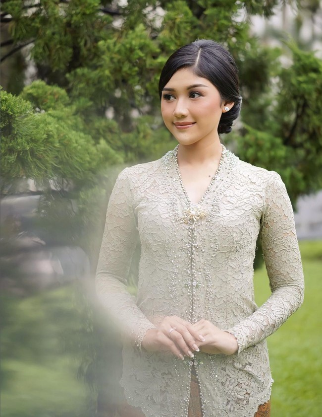 Kebaya sage berbahan lace dengan aksen mutiara serta hiasan bros ini terlihat simpel dan manis. Padukan busana dengan riasan dan tatanan rambut yang juga minimalis. Foto: Instagram/@erinagudono