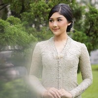 Kebaya sage berbahan lace dengan aksen mutiara serta hiasan bros ini terlihat simpel dan manis. Padukan busana dengan riasan dan tatanan rambut yang juga minimalis. Foto: Instagram/@erinagudono
