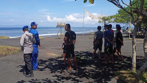 Keluarga Dewa Gede Puja, nelayan yang hilang terseret ombak di pantai Pasir Putih, Karangase,.saat menunggu tim SAR, Minggu (11/6/2023). (I Wayan Selamat Juniasa)