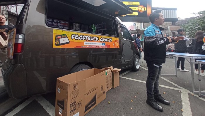 Aksi bagi-bagi makanan gratis lewat food truck.