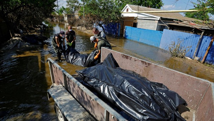 Volunteers and municipal workers place bags containing bodies retrieved from flooded houses in a vehicle after floodwaters receded following the collapse of the Nova Kakhovka dam in the course of Russia-Ukraine conflict, in the town of Hola Prystan in the Kherson region, Russian-controlled Ukraine, June 16, 2023. REUTERS/Alexander Ermochenko