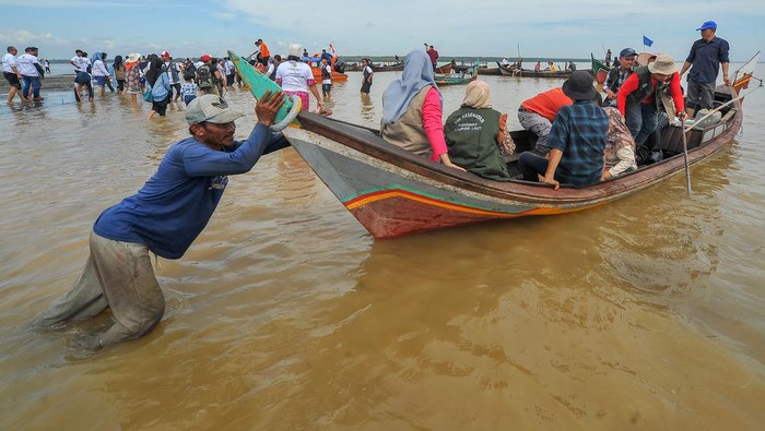 Festival Kampung Laut di Jambi Foto udara sejumlah pengunjung berjalan di muara sungai yang surut (beting) saat digelarnya Festival Kampung Laut di Tanjung Jabung Timur, Jambi, Minggu (18/6/2023). Fenomena surutnya air laut selama sekitar dua jam yang merupakan rangkaian Festival Kampung Laut tersebut dimanfaatkan ratusan pengunjung untuk memancing (mutik) sumbun (Solen grandis) di beting itu. ANTARA FOTO/Wahdi Septiawan/YU