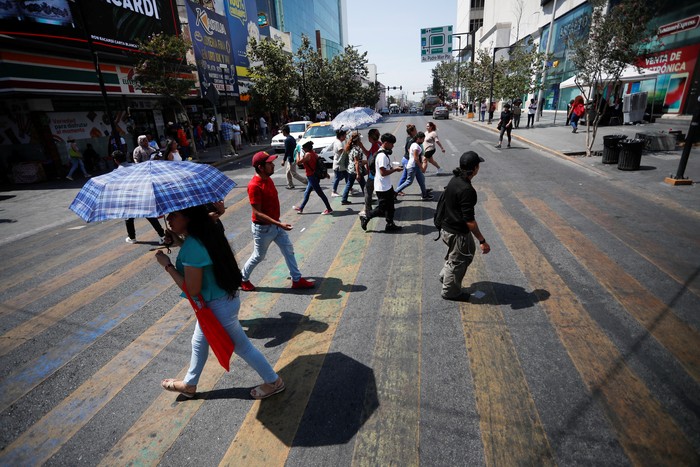 A man watches television while cooling himself with an electric ventilator as temperatures rise during an unusual heat wave, in Monterrey, Mexico June 15, 2023. REUTERS/Daniel Becerril