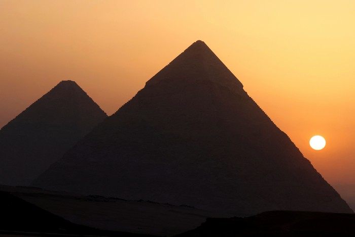 The sun rises behind the Pyramids in Giza, on the outskirts of Cairo, Egypt, June 16, 2023. REUTERS/Mohamed Abd El Ghany