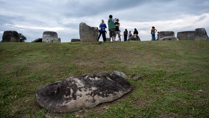 Sejumlah pengunjung mengamati Kalamba atau bejana batu raksasa di kawasan Situs Megalit Pokokea, Desa Baliura, Lore Tengah, Poso, Sulawesi Tengah, Sabtu (17/6/2023). Sedikitnya terdapat 950 titik persebaran benda peninggalan zaman batu sejenis bejana dan patung berusia lebih dari 3000 tahun di kawasan itu dan untuk menarik kunjungan wisata, Pemerintah Provinsi Sulawesi Tengah akan mencanangkan tahun ini sebagai tahun kunjungan wisata dengan tagline Negeri Seribu Megalit. ANTARA FOTO/Basri Marzuki