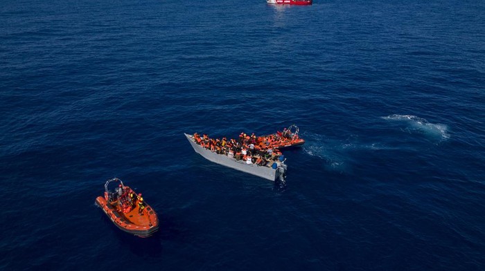 Potret Kapal Kayu Migran Terombang-ambing di Laut Mediterania Migrants from Eritrea, Libya and Sudan crowd the deck of a wooden boat as they are assisted by aid workers of the Spanish NGO Open Arms, in the Mediterranean sea, about 30 miles north of Libya, Saturday, June 17, 2023. (AP Photo/Joan Mateu Parra)
