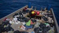 Seorang pekerja LSM Spanyol Open Arms memeriksa kapal yang digunakan para migran dari Eritrea, Libya dan Sudan, di laut Mediterania, sekitar 30 mil sebelah utara Libya, Sabtu, 17 Juni 2023.  
