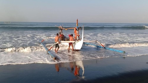 Perahu fiber nelayan yang terbalik akibat dihantam ombak besar saat di evakuasi warga setempat, Minggu (18/6/2023).