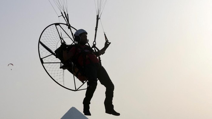 A man flies a paramotor above the Pyramids, in Giza, on the outskirts of Cairo, Egypt, June 16, 2023. REUTERS/Mohamed Abd El Ghany
