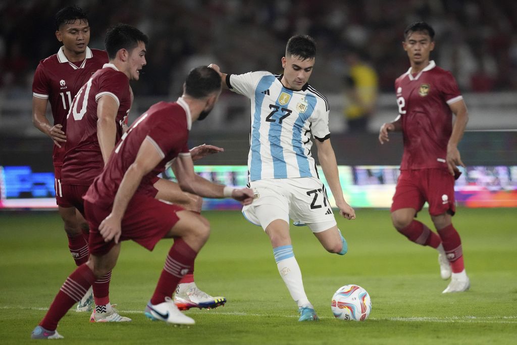 Facundo Buonanotte dari Argentina, tengah, berebut bola melawan pemain Indonesia Dendy Sulistiawan, dari kiri ke kanan, Elkan Baggott, dan Jordi Amat selama pertandingan sepak bola persahabatan mereka di Stadion Utama Gelora Bung Karno di Jakarta, Indonesia, Senin, 19 Juni 2023. (AP Photo/Achmad Ibrahim)