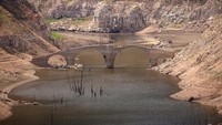 Jembatan abad pertengahan Queros muncul dari dasar Waduk Susqueda di Girona, Spanyol, Jumat (16/6/2023).