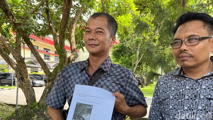 Kader Golkar Sumut, Apri Budi (kiri) saat menunjukkan postingan hoaks soal Bobby Nasution di Mapolda Sumut. (Finta Rahyuni/detikSumut)