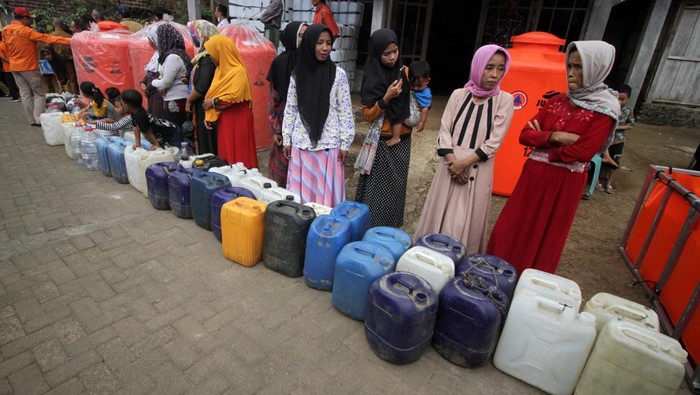 Kekeringan, Warga Mojokerto Antre Air Bersih Warga membawa air bersih yang disalurkan dari truk tangki di Desa Kunjorowesi, Ngoro, Kabupaten Mojokerto, Jawa Timur, Senin (19/6/2023). Bantuan air bersih yang disalurkan Badan Penanggulangan Bencana Daerah (BPBD) bekerja sama dengan pemda setempat tersebut untuk membantu warga yang kesulitan mendapatkan air bersih akibat musim kemarau. ANTARA FOTO/Umarul Faruq/tom.