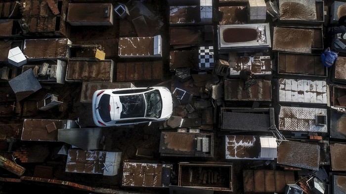 Mobil Nyungsep di Pemakaman Brasil Gegara Terseret Badai A damaged vehicle lays in a cemetery after heavy rains in Caraa, Rio Grande do Sul state, Brazil, Sunday, June 18, 2023. Authorities said at least eight people are dead and 19 are missing after a severe winter storm swept through the region. (AP Photo/Wesley Santos)