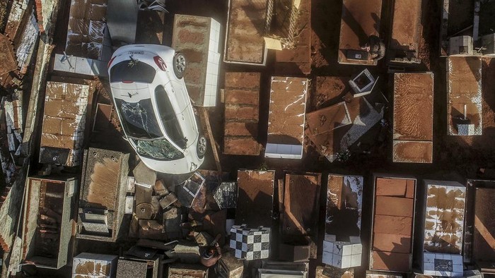 Mobil Nyungsep di Pemakaman Brasil Gegara Terseret Badai A damaged vehicle lays in a cemetery after heavy rains in Caraa, Rio Grande do Sul state, Brazil, Sunday, June 18, 2023. Authorities said at least eight people are dead and 19 are missing after a severe winter storm swept through the region. (AP Photo/Wesley Santos)