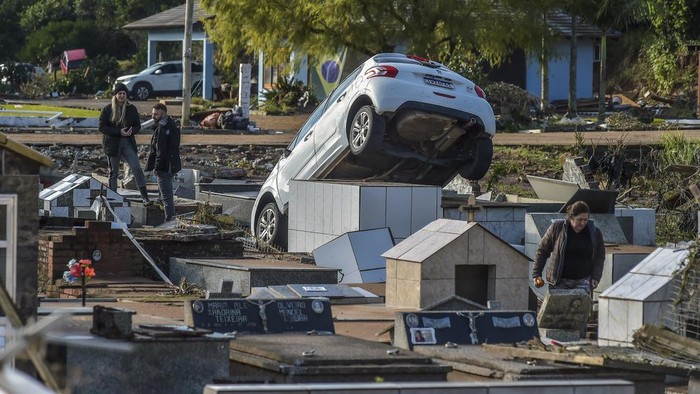 A damaged vehicle lays in a cemetery after heavy rains in Caraa, Rio Grande do Sul state, Brazil, Sunday, June 18, 2023. Authorities said at least eight people are dead and 19 are missing after a severe winter storm swept through the region. (AP Photo/Wesley Santos)
