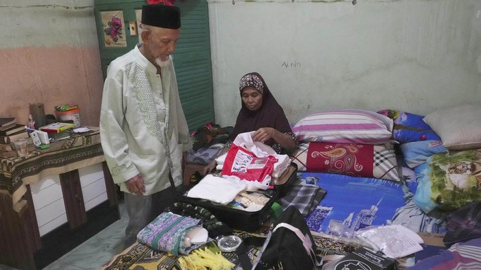 Husin bin Nisan, center, bids farewell to relatives prior to his departure for the hajj pilgrimage at his house in Tangerang, Indonesia, Tuesday, June 6, 2023. (AP Photo/Achmad Ibrahim)